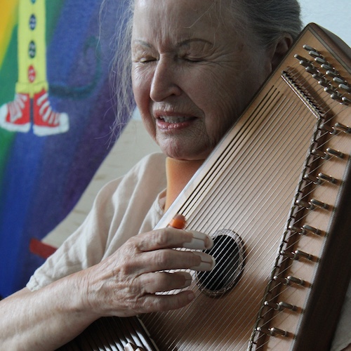 A woman plays an autoharp