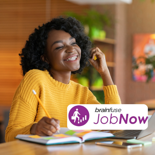 A young woman smiles in front of a computer
